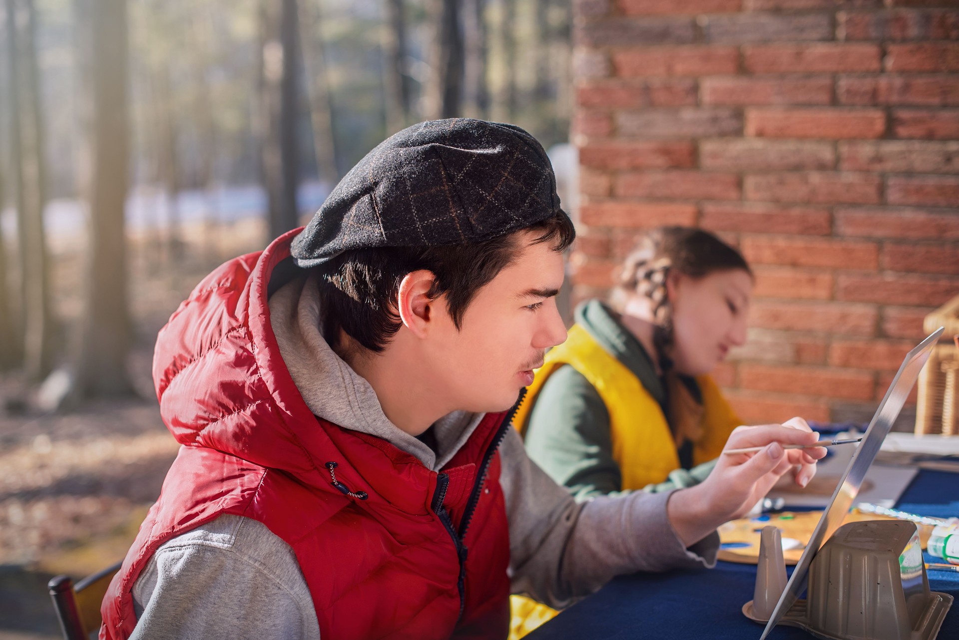 Teenagers prepare homemade gifts. Autistic brother and sister work together on porch in Pennsylvania spring.